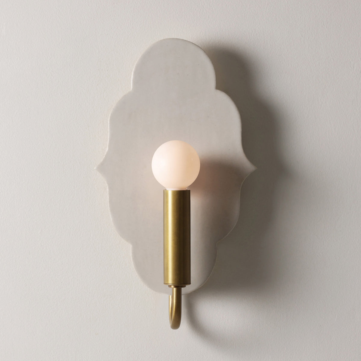 Clare Ceramic Sconce shown in Heirloom Brass with a Natural White Glaze