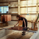 Japanese artisan applying kakishibu dye to washi paper for our Maru paper shades