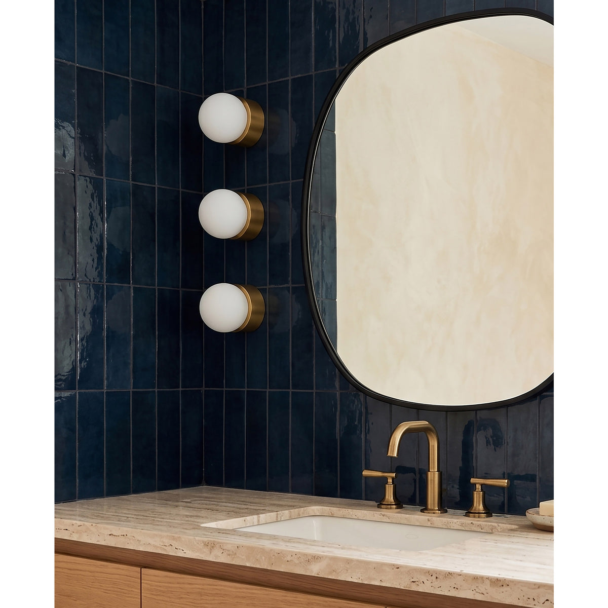 Brass Cutie Small sconces shown in Heirloom Brass as bathroom vanity lights. 