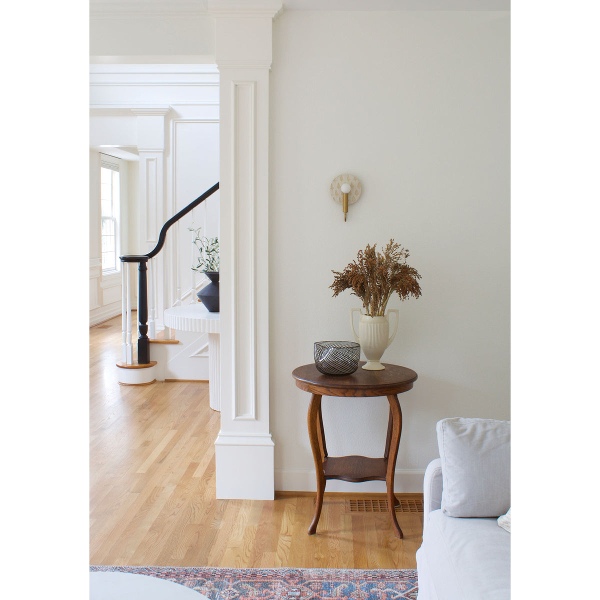 Edith ADA Sconce shown in Heirloom Brass with a Natural White and Cream Floral Ceramic Canopy