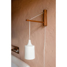 Tumwater 14" Wood Arm Sconce shown in Walnut with a White Plug-in Cord. Photo by Posada Inn by The Joshua Tree House