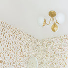 Trillium shown in Brass with 6" Opal globes. Interior Design by Joy Cho